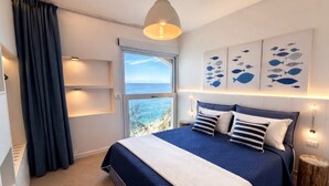 A bedroom with a bed, a window, a curtain, and wall art. - "CASA POMONTE" ON THE SEA with PRIVATE PARKING SPACE. (Pomonte)