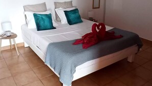 Un dormitorio con una cama, una mesita de noche, aire acondicionado de pared y una lámpara colgante.