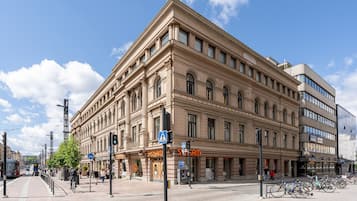 Suuri, historiallinen rakennus, jossa on useita kerroksia, näyttävä sisäänkäynti ja pyöräparkki.