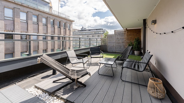 A rooftop terrace with outdoor seating, a view of adjacent buildings, and a clear sky. - 1BR Penthouse with Sauna & Private Rooftop Terrace (Tampere)