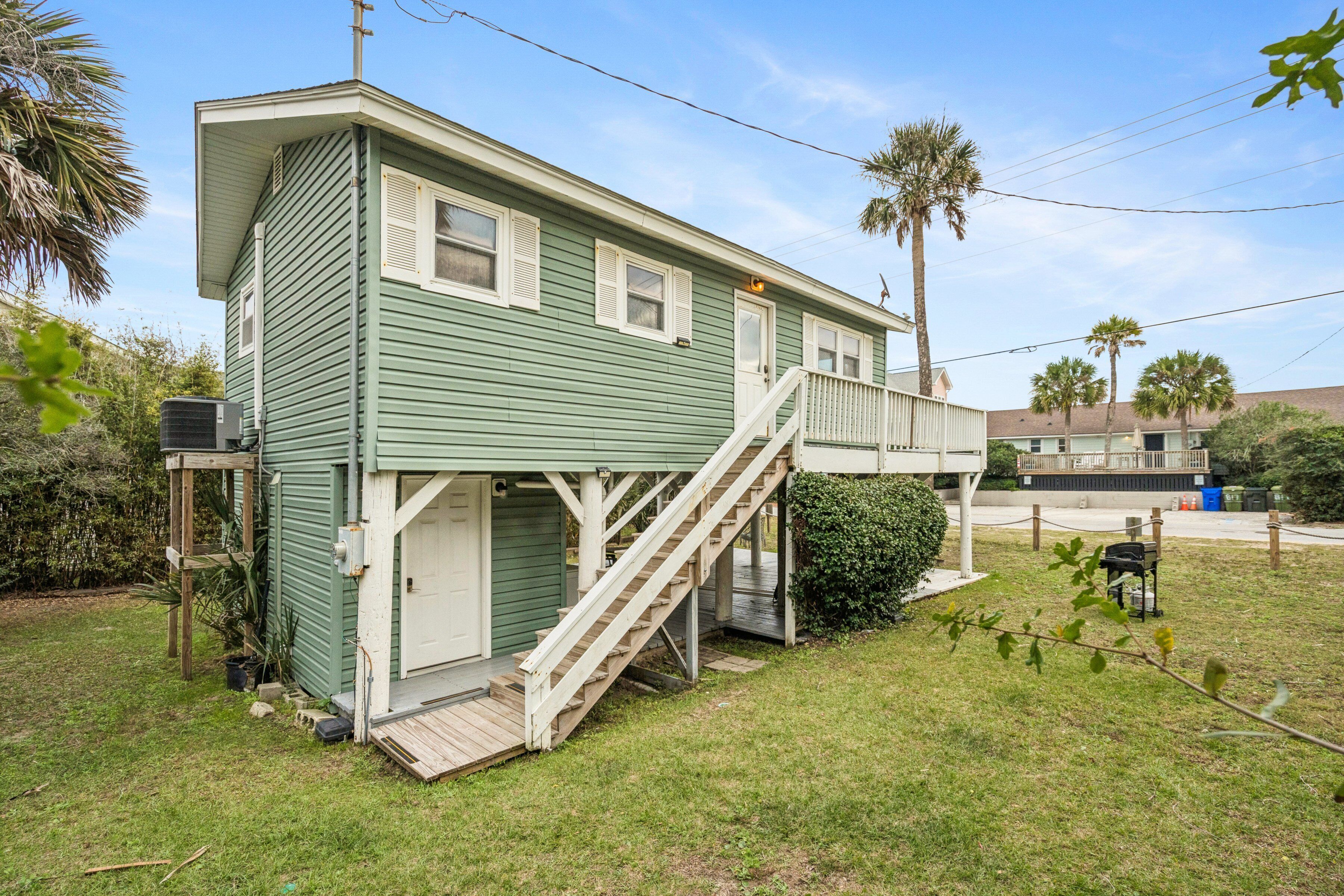 A two-story house with a covered porch and a wooden staircase leading to the second floor.