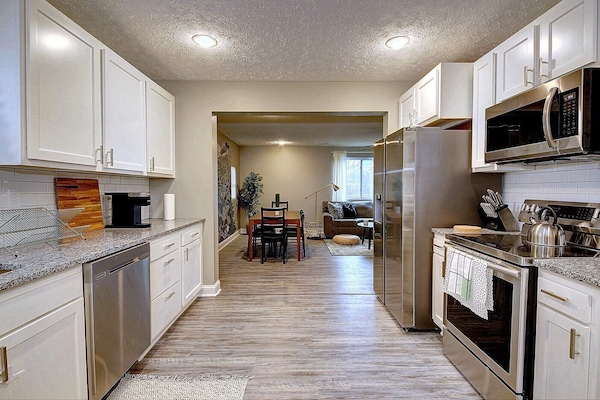 Spacious kitchen with granite counters, subway tile backsplash and appliances.