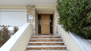 A set of stone steps leading to a wooden door with a sign above it.