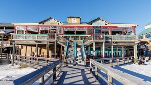 A pier leading to a multi-story building with balconies and outdoor seating areas. - ETW 3001: Cozy Cove - Gulf of Mexico Tides... Nature’s Perfect Rhythm (Fort Walton Beach)