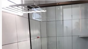 Une petite salle de bain fermée, comprenant des toilettes, un lavabo et un espace douche.