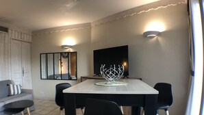 Un espace repas moderne avec une table en bois, des chaises noires et un centre de table décoratif en forme de bol en métal.