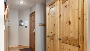 A hallway with wooden doors, a fire extinguisher, and a small wooden table.
