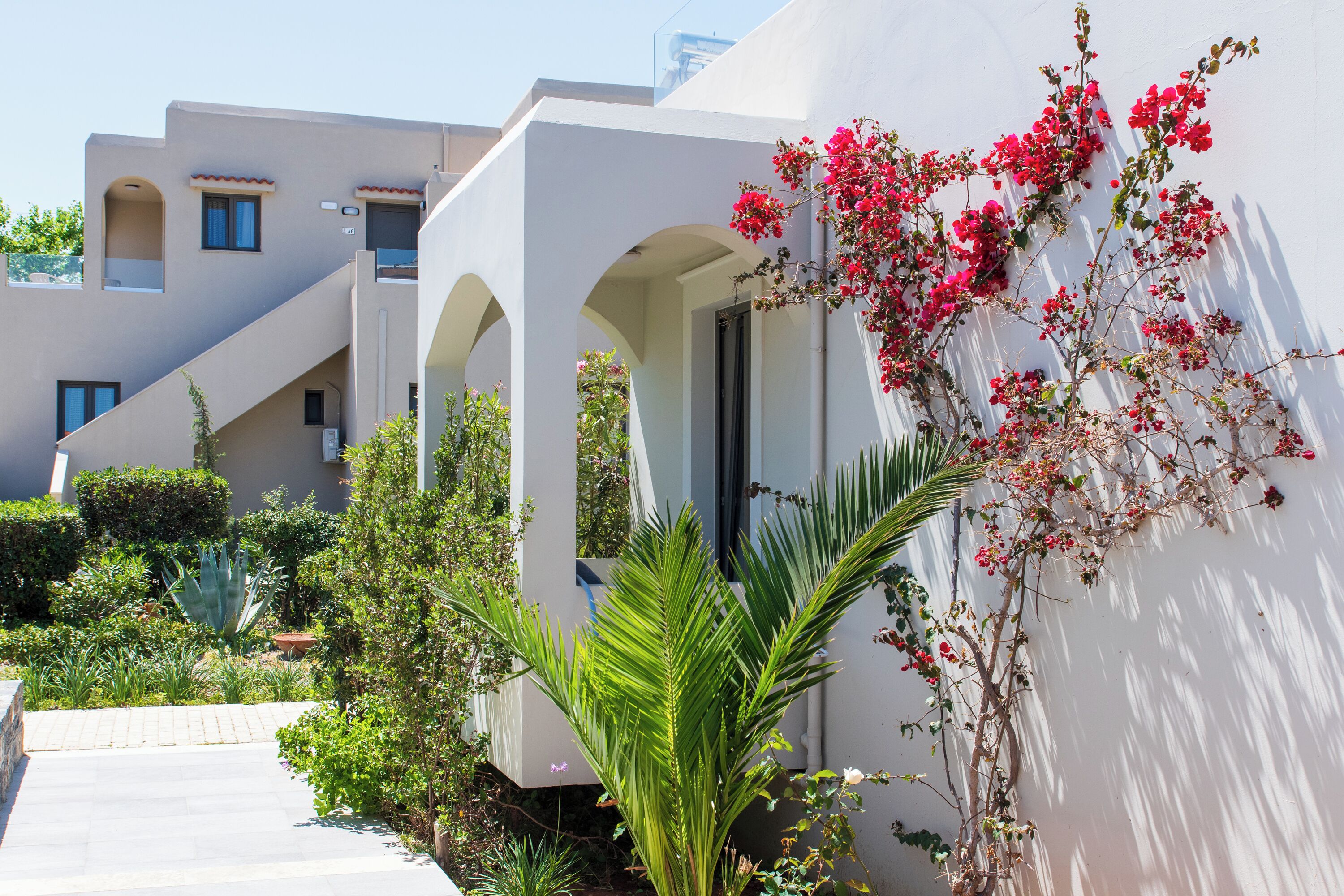 A modern building with white walls and multiple balconies.