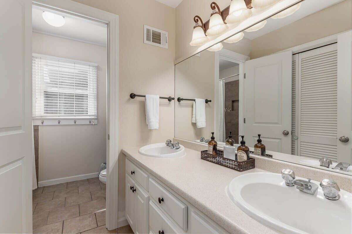 A bathroom with two sinks, a large mirror, and a towel rack.