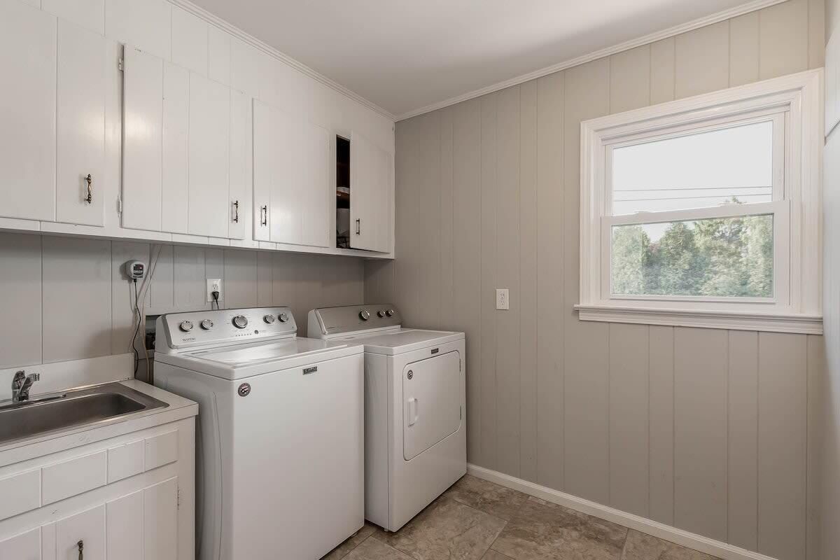 A laundry room with a washing machine, dryer, and a sink.