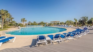A swimming pool with blue water, surrounded by lounge chairs and palm trees. - Harbor Point Ocean Front Beach Estate (Saint Helena Island)