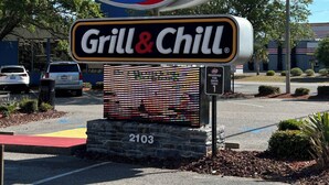 En DQ Grill & Chill-skylt med en digital meny.