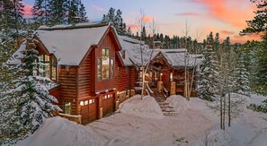 A log cabin with a snow-covered roof, surrounded by a forest. - True ski in/out Breckenridge, luxury home, hot tub, great room, locally managed (Breckenridge)