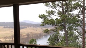 A wooden deck with a view of a river and trees. - Best view of the river! (Calico Rock)