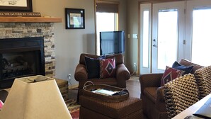A cozy living room with a fireplace, comfortable seating, and a television. - Best view of the river! (Calico Rock)
