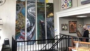 A modern interior with a black leather sofa, a ceiling with intricate designs, and a large mural depicting various landscapes. - Best view of the river! (Calico Rock)
