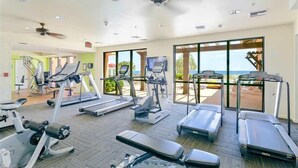 Un gimnasio con cintas de correr, elípticas y bancos de pesas.