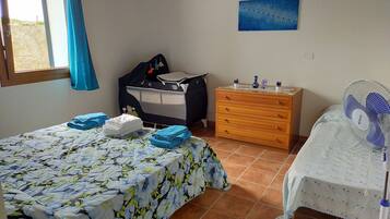 Relax in this serene bedroom with a large bed, dresser, and bedside table, surrounded by wall-mounted artworks.