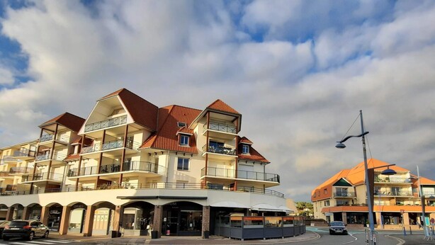 A multi-story hotel with balconies, a covered entrance, and a parking area. - l'Art de l'eau beach studio on private property (NEUFCHÂTEL-HARDELOT)