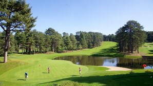 A golf course with a pond, trees, and a clear sky. - l'Art de l'eau beach studio on private property (NEUFCHÂTEL-HARDELOT)