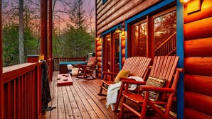 A wooden deck with rocking chairs and a hot tub. - Booking Summer! 4 Masters Family Friendly Hot Tub Fire Pit Secluded Yard (Sevierville)