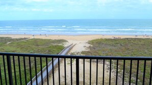 A beach view from a balcony with a railing, sandy beach, and ocean. - Modern Oceanfront condo for your Beach Getaway! Spectacular views! (South Padre Island)