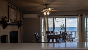 Una cocina con una isla grande, un ventilador de techo y vistas al océano a través de amplios ventanales.