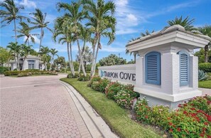 Segnale stradale per Tarpon Cove, con una strada asfaltata e palme sullo sfondo.