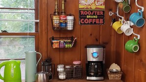 Eine Küche mit einer Kaffeemaschine, einem Wasserkocher und einem Schild mit Kaffee-Motiv.