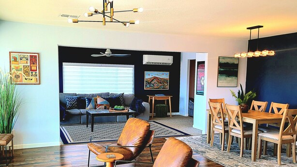 A living room with a sofa, two leather chairs, a dining table with chairs, a patterned rug, and a ceiling fan. - The Dorado Blue ~Spectacular views (Bullhead City)