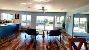 A hotel lobby with a wooden floor, a reception desk, two chairs, and large windows offering a view of the outside. - The Dorado Blue ~Spectacular views (Bullhead City)