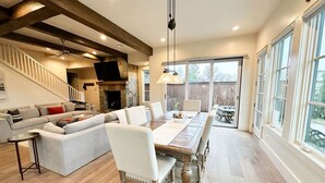 A spacious living room with a large sectional sofa, a wooden dining table, and a fireplace. - 15% off gorgeous cottage, hot tub, pool, fishing ponds, streams, waterfalls! (Vinita)