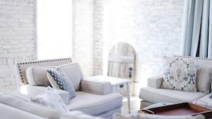 A modern living room with a white brick wall, a sofa, and a small table. - Charming Loft (Nashville)