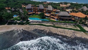 A resort with multiple buildings, a swimming pool, and a beach.