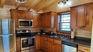 Une cuisine avec des meubles en bois, des appareils électroménagers en acier inoxydable et un lave-vaisselle.