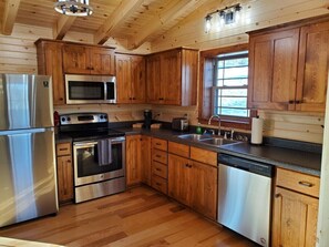 A kitchen with wooden cabinets, stainless steel appliances, and a dishwasher.