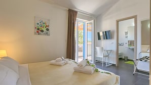 A hotel room with a bed, a TV, a bathroom, and a balcony. - Lovely home in Naselje Muzini with sauna (Naselje Muzini)