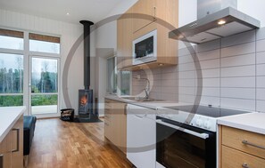 Enjoy cooking with a wood-burning stove, oven, and microwave in this well-equipped kitchen.