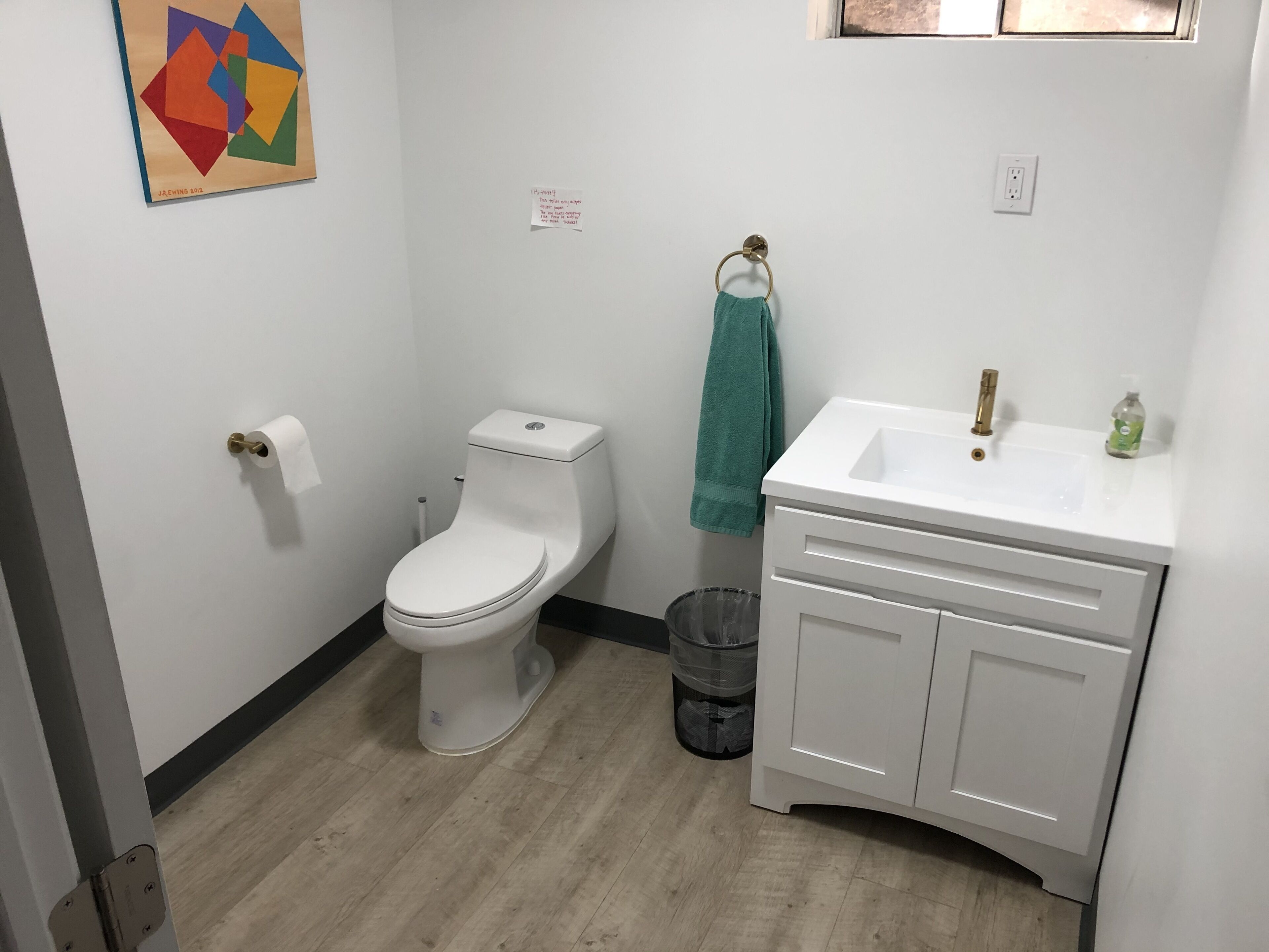 Ein Badezimmer mit Toilette, Waschbecken und Mülleimer.