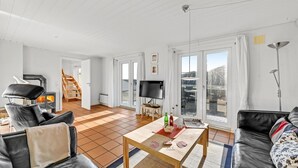 Un salon spacieux doté d’une cheminée, d’un téléviseur et offrant une vue sur l’extérieur.