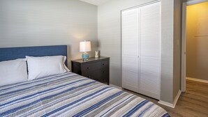A bedroom with a bed, nightstand, lamp, and a wardrobe. - Centro Ybor Duplex! Walk to 7th Ave! Unit E12th-B (Tampa)