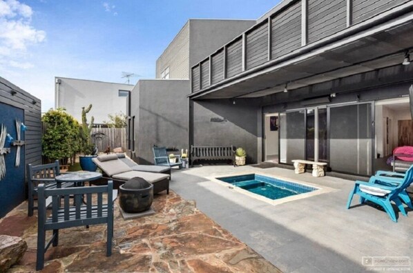 Relax by the pool in a serene outdoor space with lounge chairs and a shaded seating area.