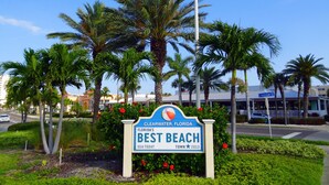Schild für 'Best Beach' in Clearwater, Florida, mit Palmen und blauem Himmel im Hintergrund.