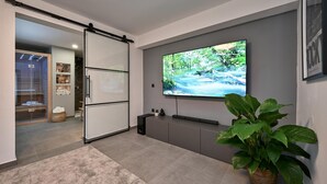 A modern bathroom with a glass shower enclosure, a large mirror, and a flat-screen TV mounted on the wall. - Gorgeous home in Popovaca with sauna (Popovaca)