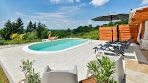 A swimming pool with a swan float, lounge chairs, and a wooden fence. - Gorgeous home in Popovaca with sauna (Popovaca)