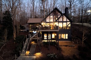 A modern two-story house with a balcony, a staircase, and a chimney.