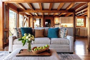 Open-concept A-frame living room at the Hygge House — warm wood beams, modern furnishings & lakefront views make this Gainesville, GA cabin the perfect cozy escape for couples & families.