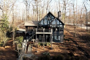 Daytime aerial of the Hygge House — soaring floor-to-ceiling windows, wraparound deck & wooded path to Lake Lanier show why guests say this Gainesville, GA cabin is better than the pictures.