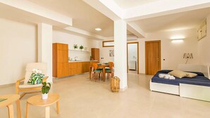 Un appartement moderne comprenant un coin repas, une cuisine et une chambre.