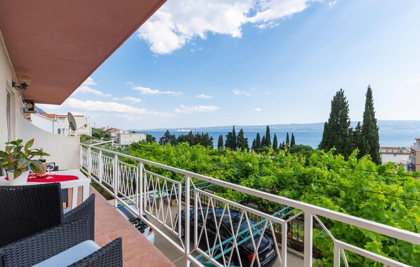 Ein Balkon mit Blick auf einen Weinberg und das Meer.
